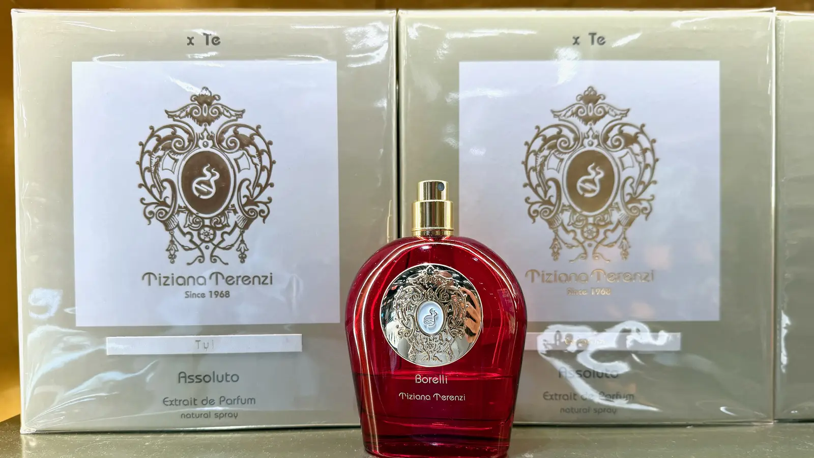 An unboxed Tiziana Terenzi Borelli bottle standing in front of two sealed retail boxes on a shop shelf