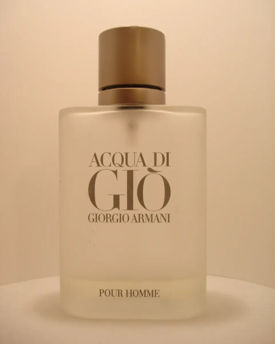 Frosted glass bottle of Acqua di Giò pour Homme by Giorgio Armani on a plain background