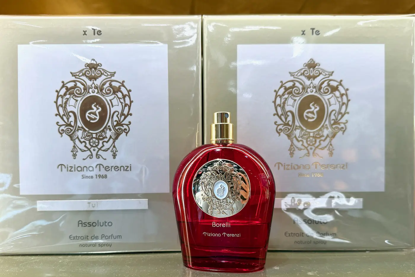 Tiziana Terenzi Borelli bottle between two sealed, cellophane-wrapped Tiziana Terenzi retail boxes on a store shelf